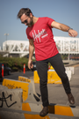 Model in TUY Higher Life red T-shirt by Urbaxo, styled with casual bottoms, showing off the vibrant color and laid-back fit